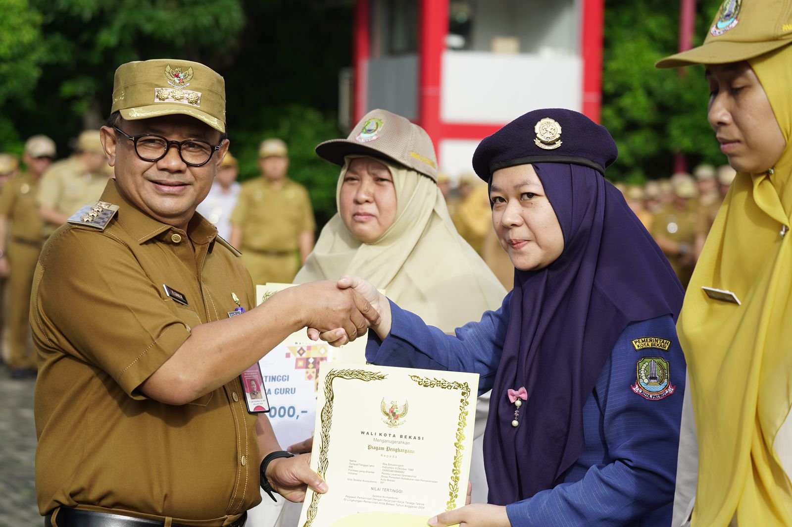 Foto : Pj Wali Kota Bekasi, Gani Muhamad, memberikan penghargaan kepada empat calon PPPK dengan nilai Uji Kompetensi tertinggi di apel pagi rutin Kantor Pemerintah Kota Bekasi.