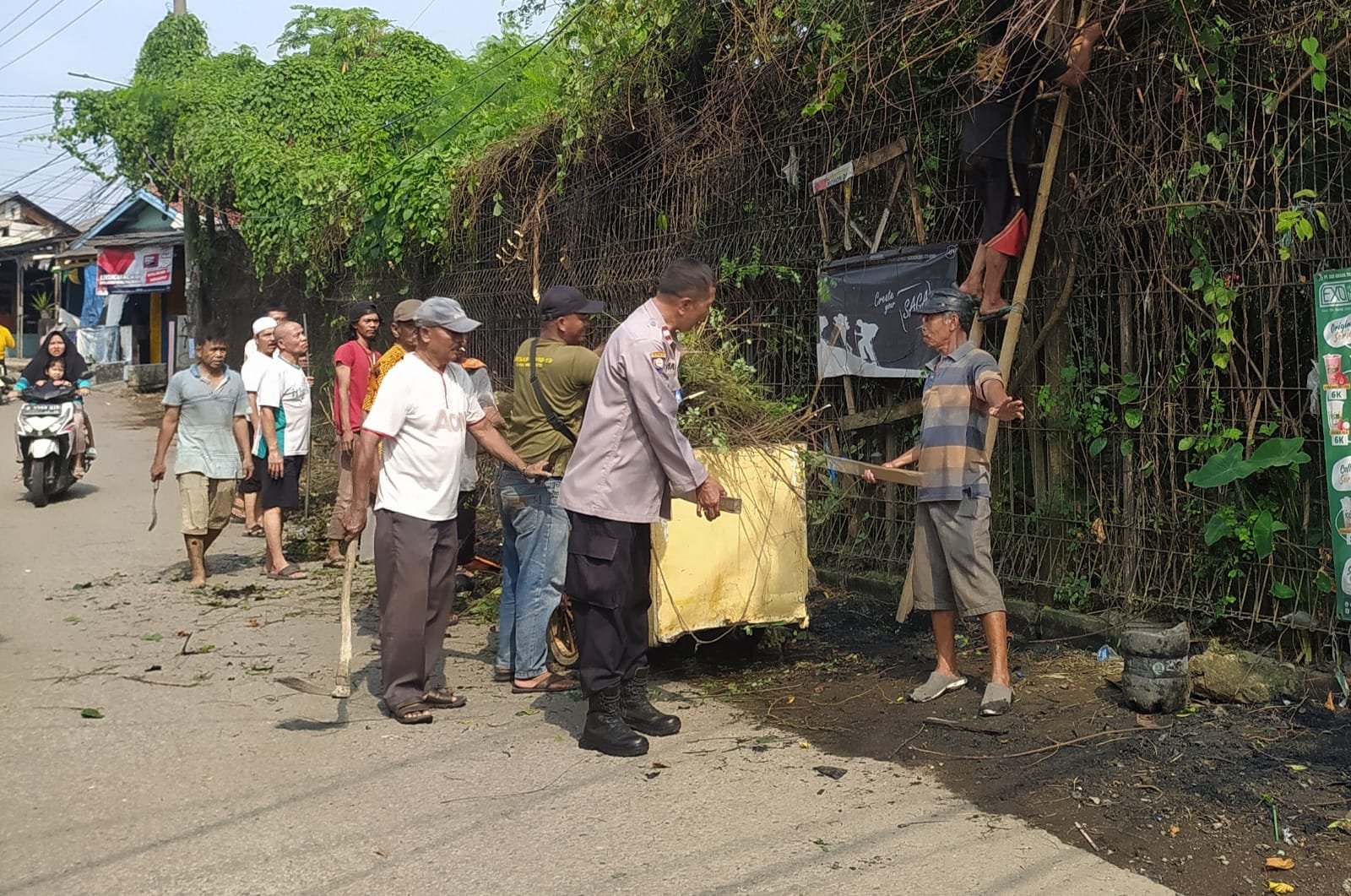 Petugas Polsek Cikarang Pusat bersama warga membersihkan lingkungan dalam kerja bakti di Kampung Rawasentul, Jayamukti, Cikarang Pusat, Kabupaten Bekasi.